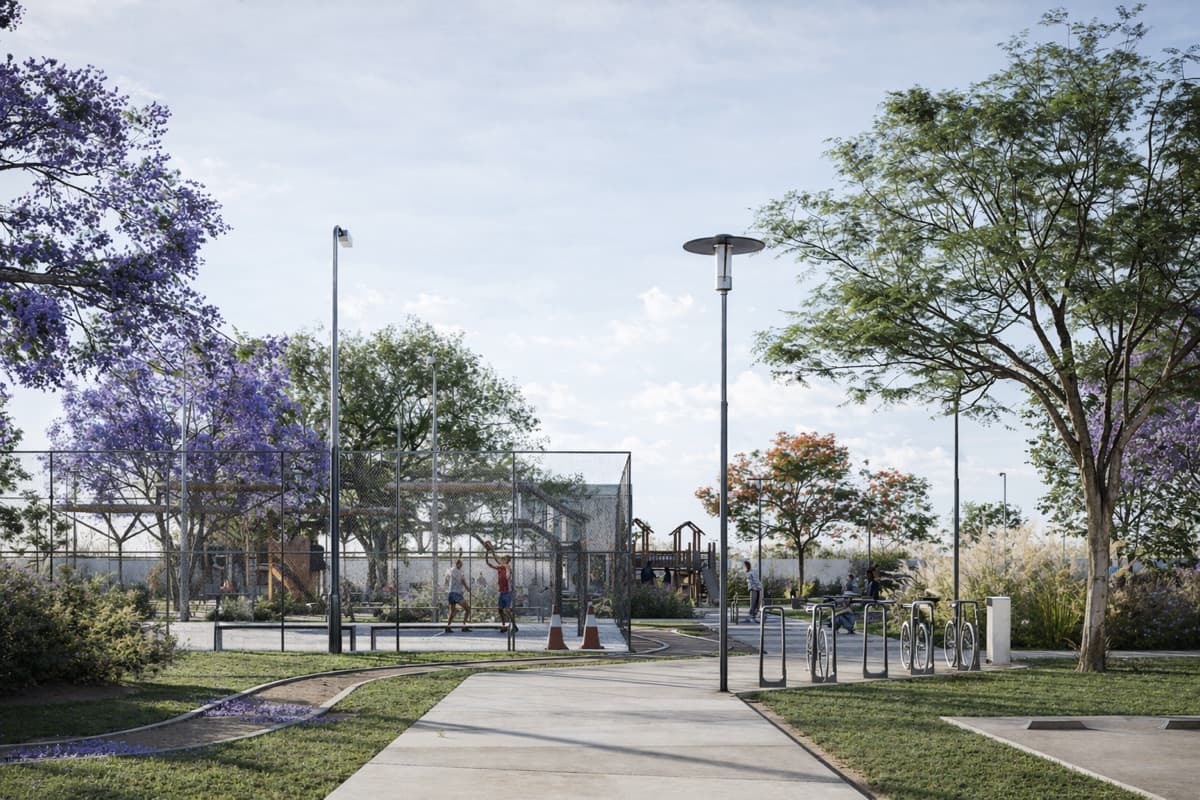 Pista para correr con bicicleteros y vegetación en VERA Residencial